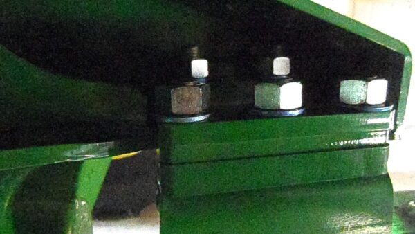 A close up of a Combine Tow Hitch for JD "S" Series 2013 and newer tractor with a couple of bolts on it.