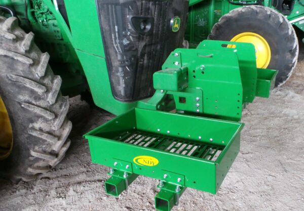 A green tractor with a Rock Box for John Deere 8000 Series without Weights attached to it.