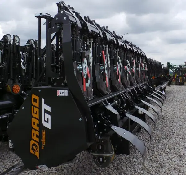 A group of Stalk Stomper for Drago GT Series 8 Row Corn Head parked in a gravel lot.