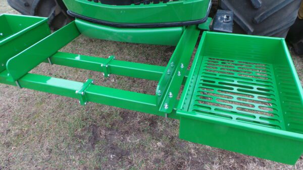 A Rock Box for John Deere 9000 Series tractor with a green tray attached to it.
