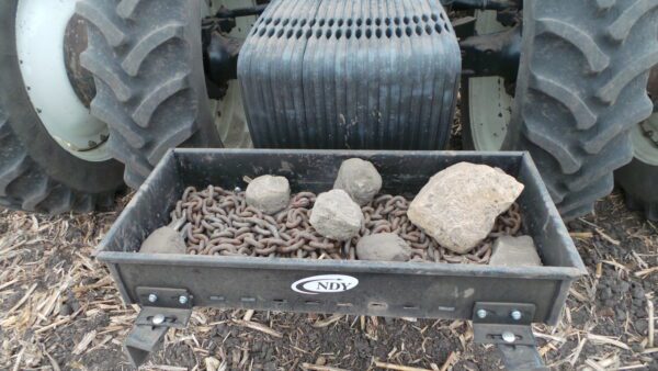 A tractor with a Rock Box for New Holland for T8 Series full of rocks and gravel.