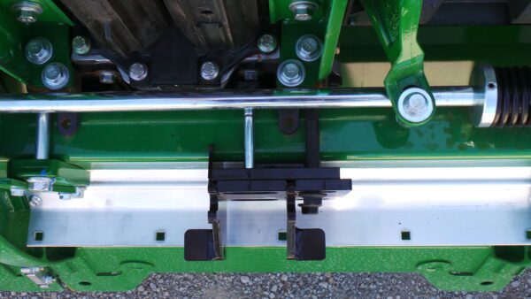 Green agricultural machinery close-up with metal components.