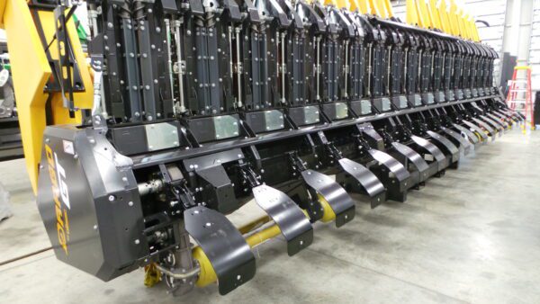 A Stalk Stomper for Drago GT Series 18 Row Corn Head in a factory with a large number of blades.