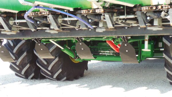 A green Stalk Stomper for 6 Row Capello and Lexion Corn Heads with a tire on it.