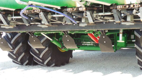 A green Stalk Stomper for 12 Row Capello and Lexion Corn Heads with a tire on it.