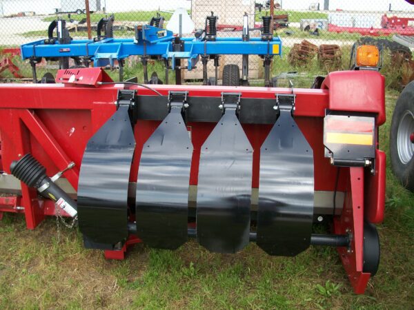A red Stalk Stomper Storage Hanger for Case 900 & 1000 Series - 4 Row tractor with two black blades attached to it.