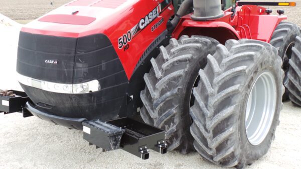 A red Rock Box for Case Steiger with Quadtrac - 400HP and Larger tractor with large tires on the ground.
