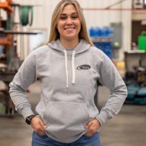 Smiling woman in a gray hoodie indoors.