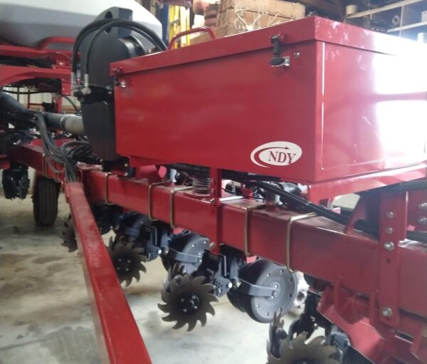 A red tractor with a Large Utility Storage Box for 12/16 row 30" Case IH 1250/1255 Planters attached to it.