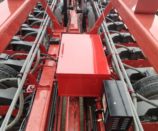 A red tractor with a Large Utility Storage Box for 24 row 30" Case IH 1250/1255 Planters on it.
