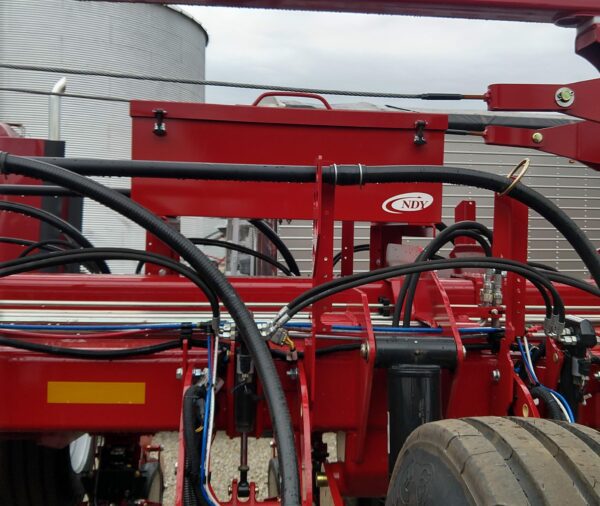 A red Large Utility Storage Box for 24 row 30" Case IH 2150 Planters with hoses attached to it.