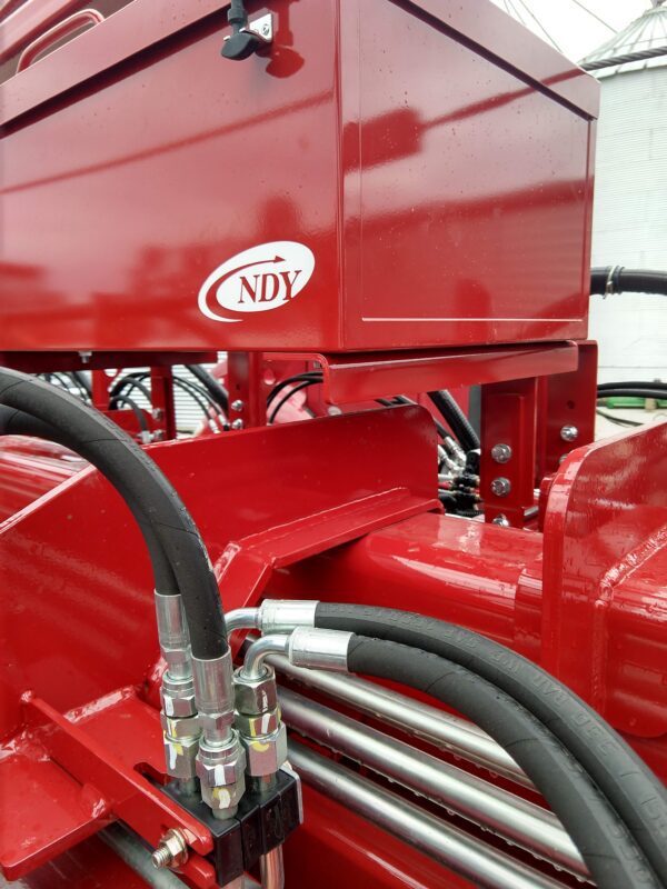 A red Large Utility Storage Box for 24 row 30" Case IH 2150 Planters with hoses attached to it.