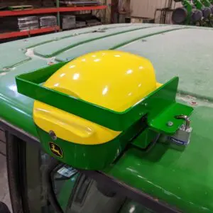 A green GPS Hinged Globe Lock for John Deere® 6000 series StarFire tractor with a yellow helmet on the hood.